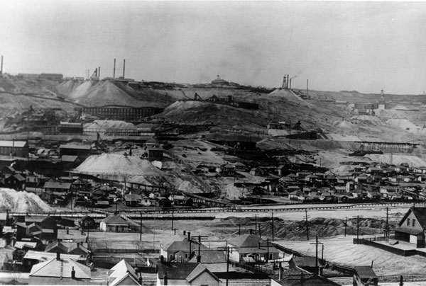 The Butte Hill in the 1890's. Notice the thick smog in the sky, produced by the numerous small smelters in the city at the time. Also note the expansive piles of acidic waste rock.